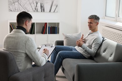 Photo of Professional psychotherapist working with patient in office