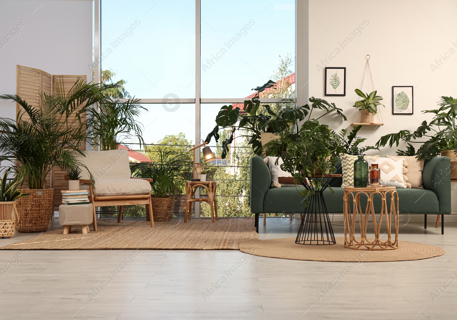 Photo of Stylish room interior with comfortable furniture and different exotic houseplants