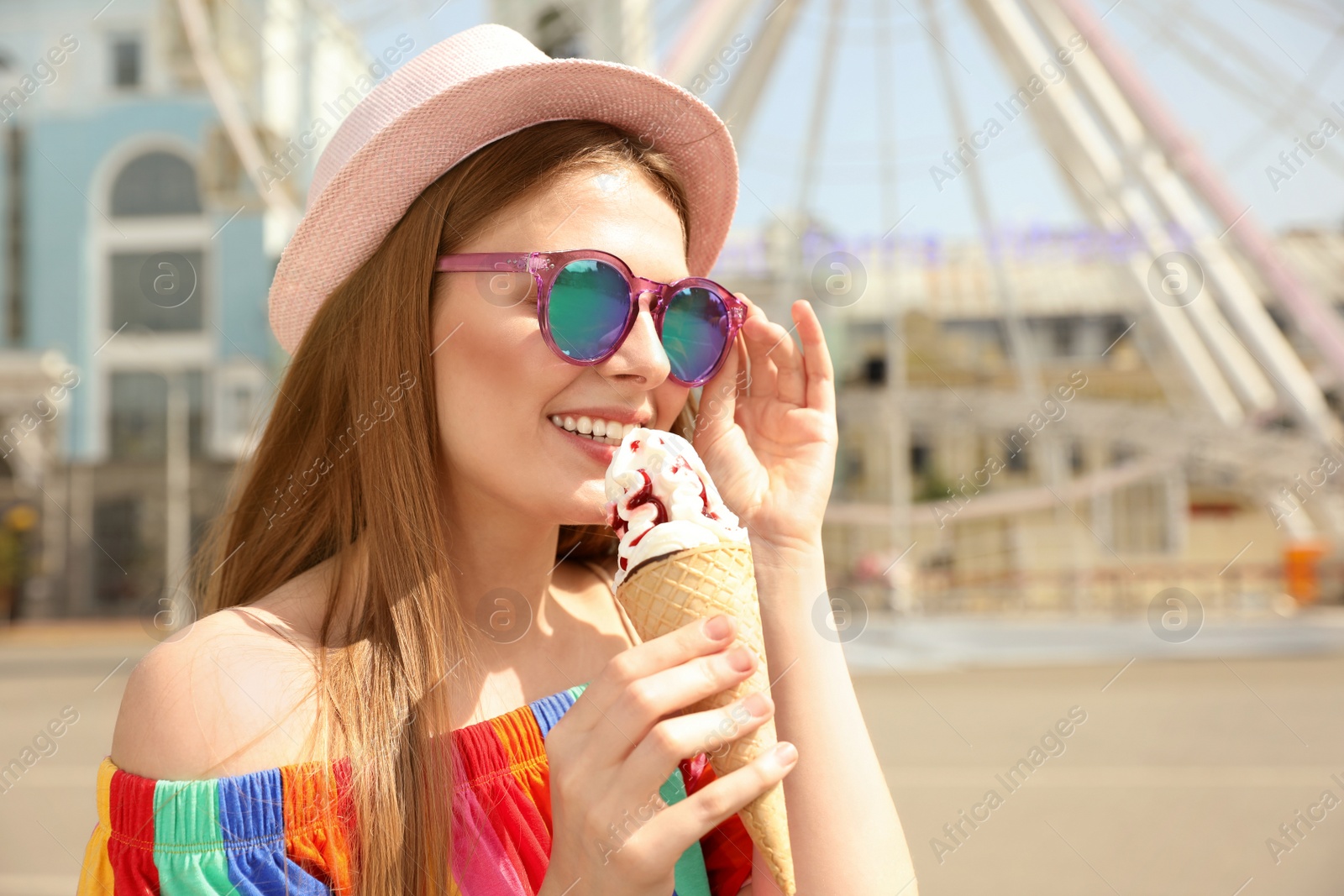 Photo of Young happy woman with ice cream cone in amusement park. Space for text