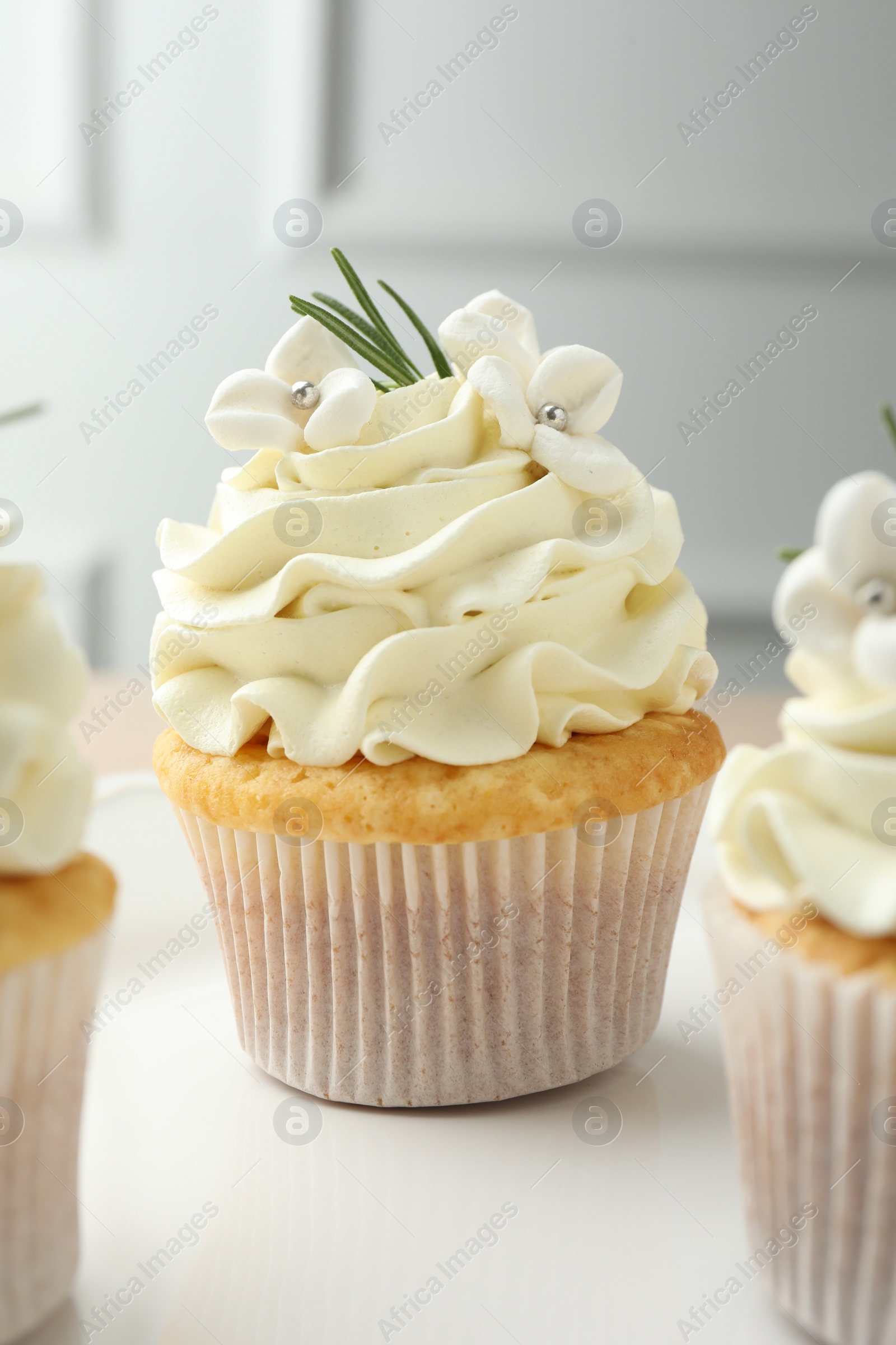 Photo of Tasty Easter cupcakes with vanilla cream on table, closeup