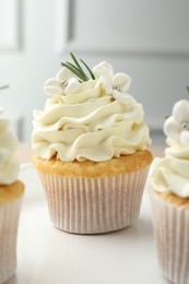 Tasty Easter cupcakes with vanilla cream on table, closeup