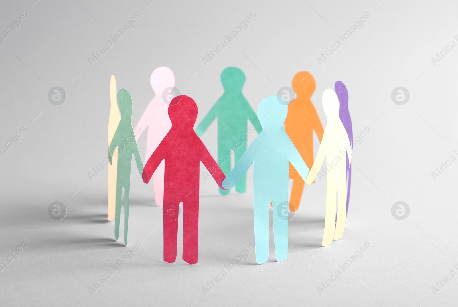 Photo of Paper human figures making circle on white background. Diversity and Inclusion concept