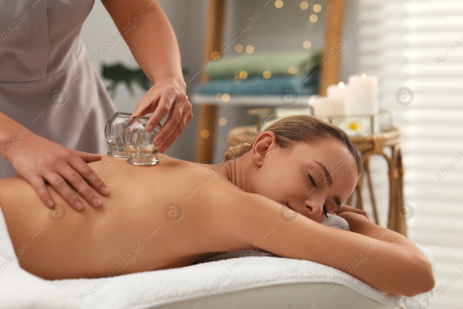 Photo of Therapist giving cupping treatment to patient in spa salon