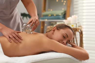Photo of Therapist giving cupping treatment to patient in spa salon