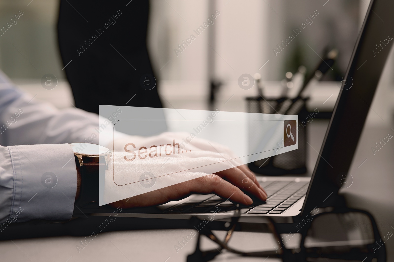 Image of Search bar of website over laptop. Man using computer at grey table, closeup
