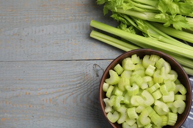Photo of Fresh cut celery stalks on grey wooden table, flat lay. Space for text