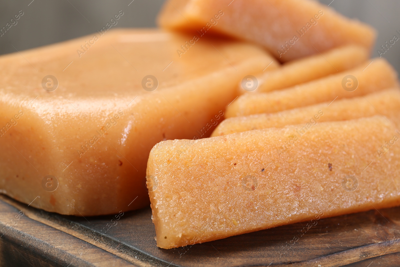 Photo of Tasty sweet quince paste on wooden board, closeup