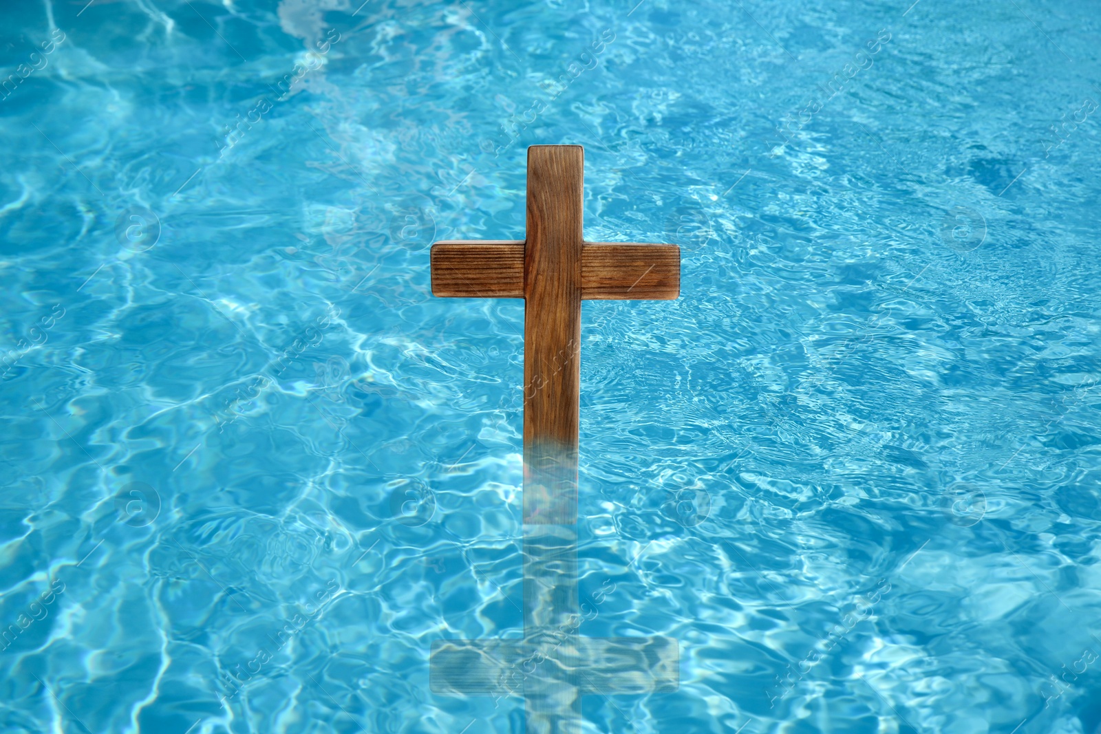 Image of Wooden cross in water for religious ritual known as baptism