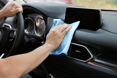 Man washing car salon with rag, closeup