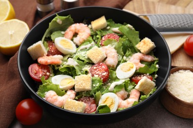 Delicious Caesar salad with shrimps on table, closeup