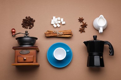 Flat lay composition with vintage manual grinder and geyser coffee maker on brown background