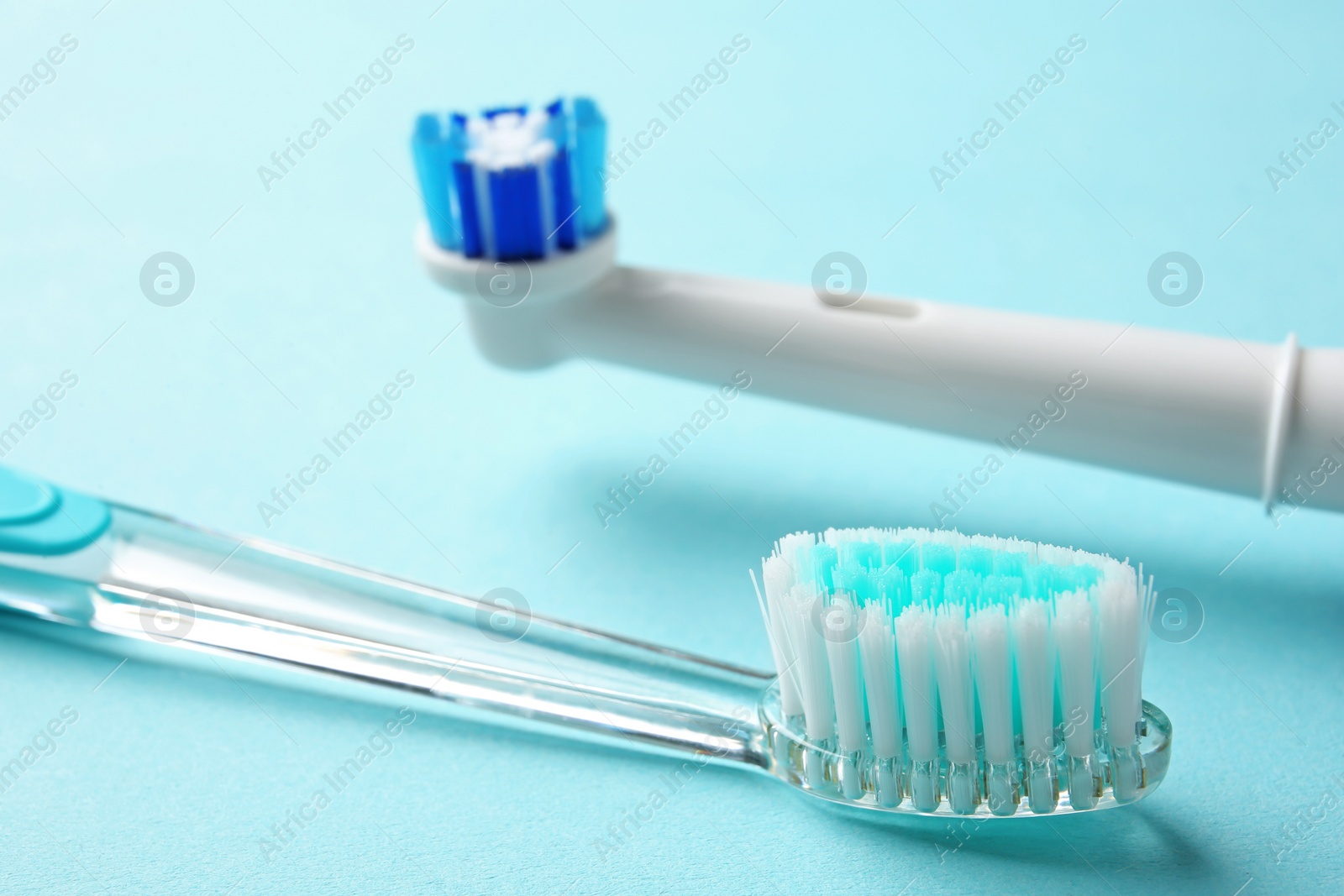 Photo of Manual and electric toothbrushes on color background, close up. Dental care