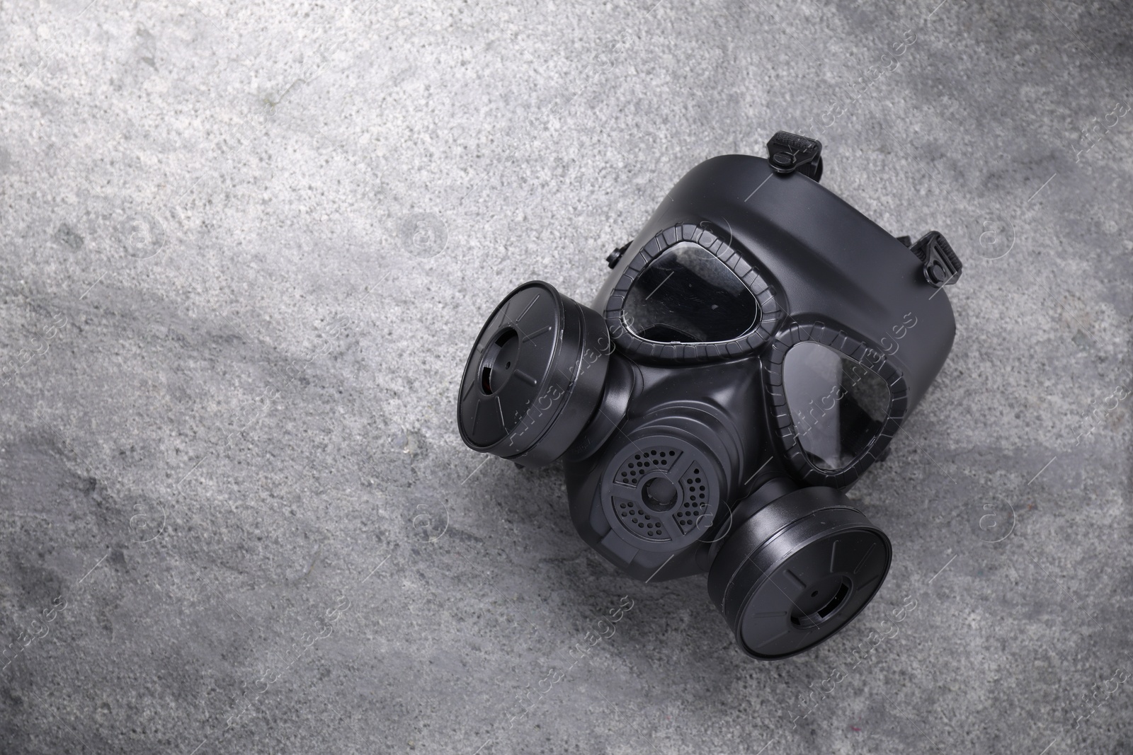 Photo of One gas mask on grey textured background, top view. Space for text