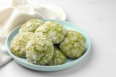 Plate with tasty matcha cookies on white table, closeup. Space for text