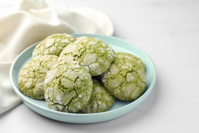 Photo of Plate with tasty matcha cookies on white table, closeup. Space for text