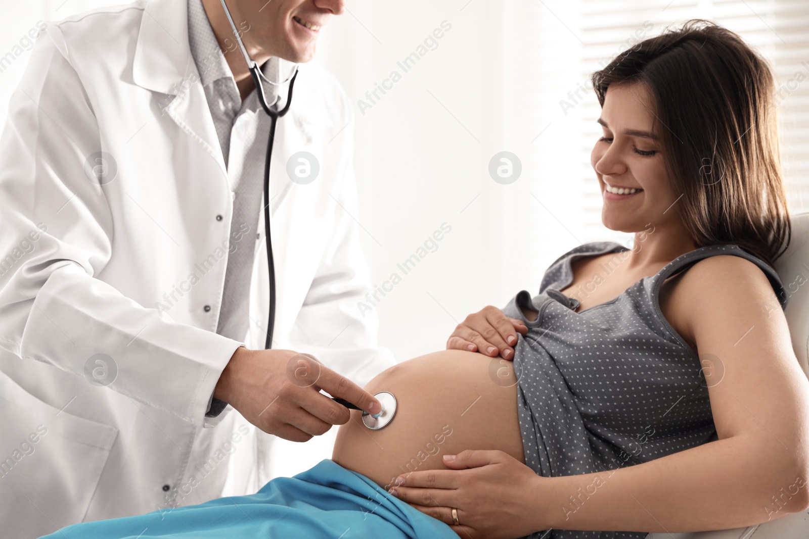 Photo of Doctor examining woman before giving child birth in maternity hospital, closeup