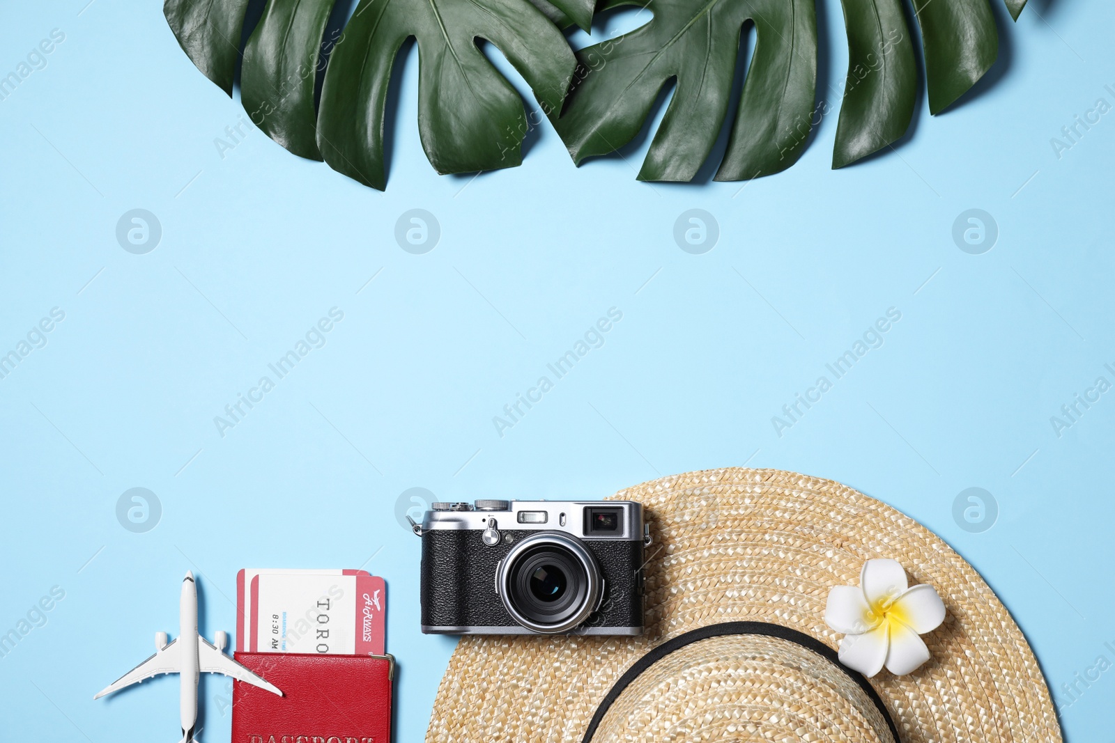 Photo of Flat lay composition with passport and camera on light blue background. Space for text