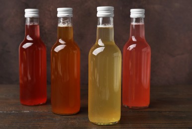 Photo of Delicious kombucha in glass bottles on wooden table