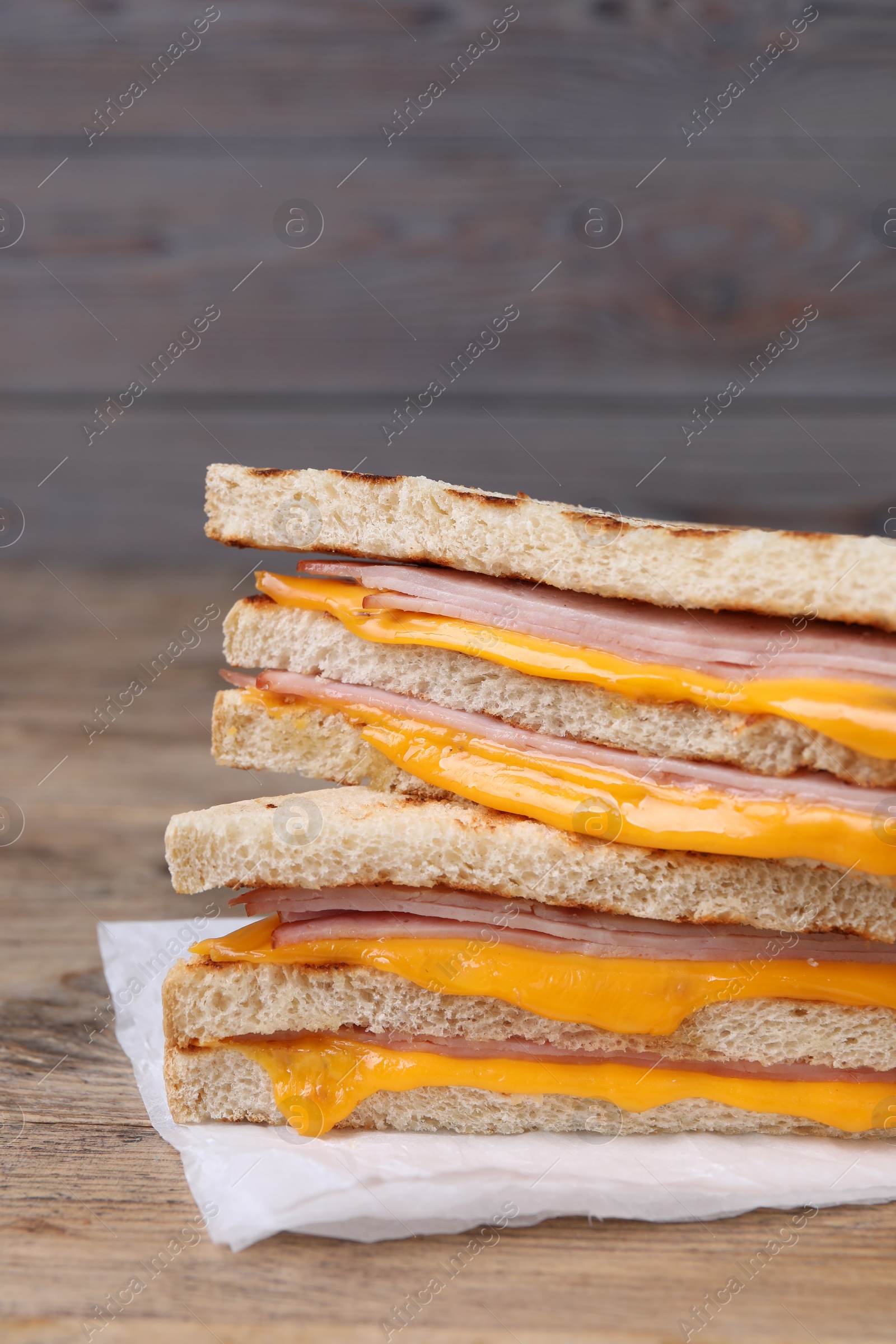 Delicious grilled sandwiches with ham and cheese on wooden table, closeup Photo of Delicious grilled sandwiches with ham and cheese on wooden table, closeup