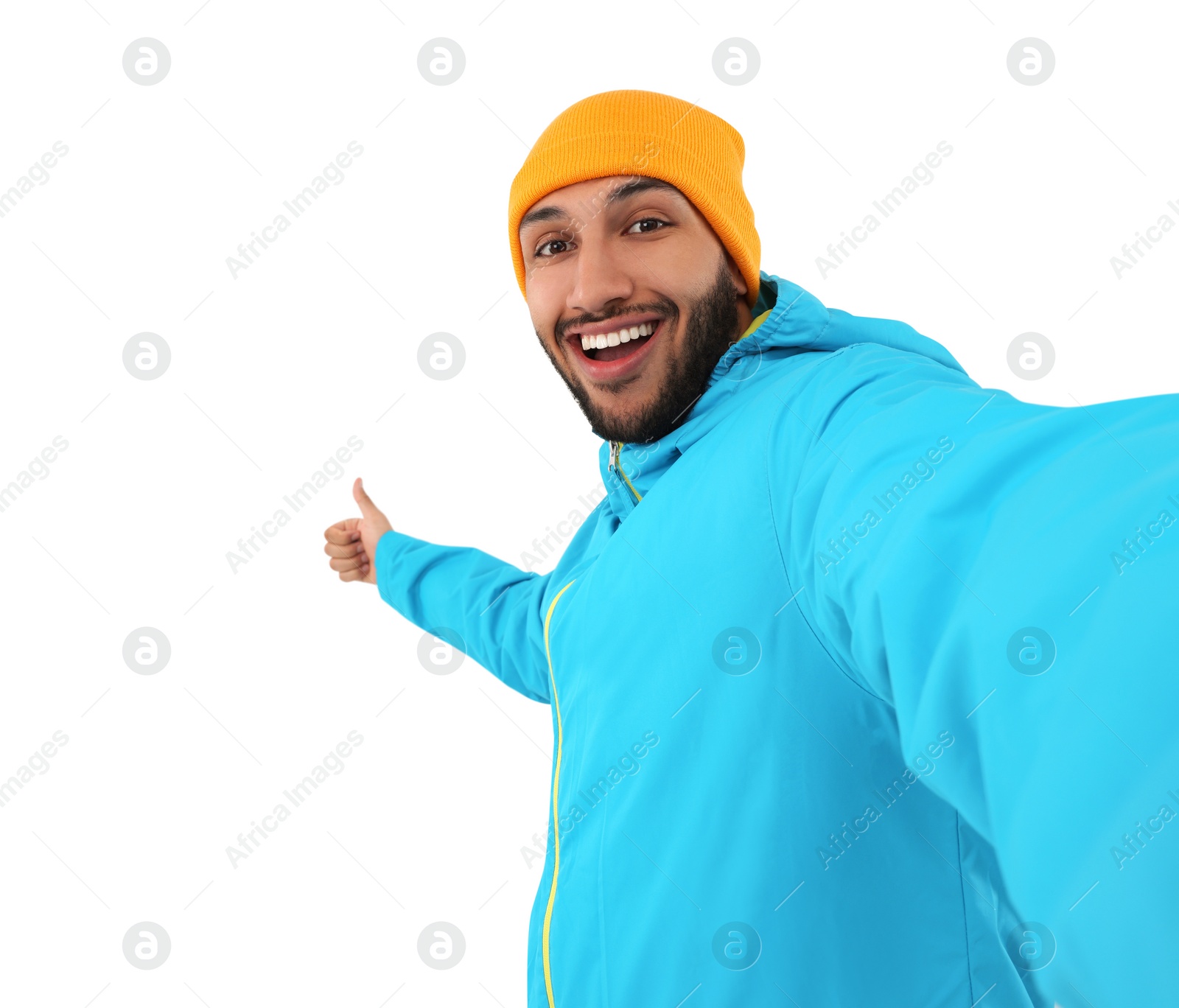 Photo of Smiling young man taking selfie and showing thumbs up on white background