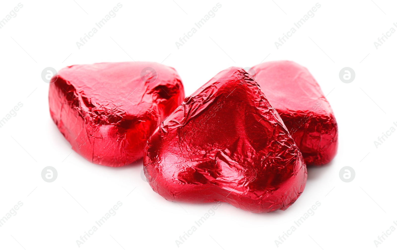 Photo of Heart shaped chocolate candies in red foil on white background