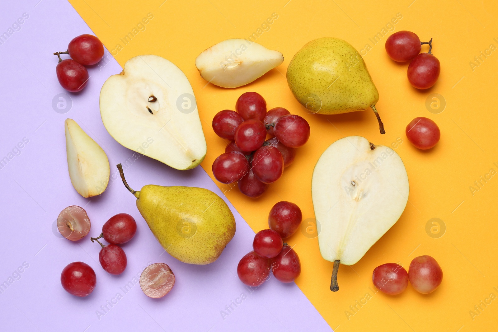 Photo of Fresh ripe pears and grapes on color background, flat lay