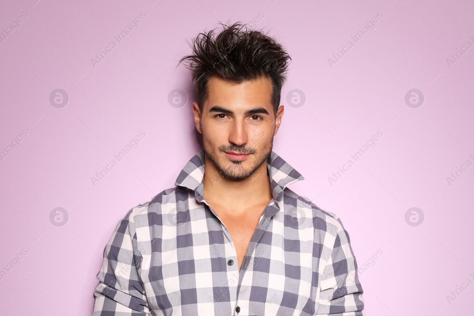 Photo of Young man with trendy hairstyle posing on color background