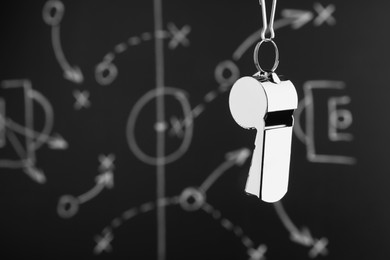 Photo of Referee whistle against chalkboard with game scheme, closeup. Space for text
