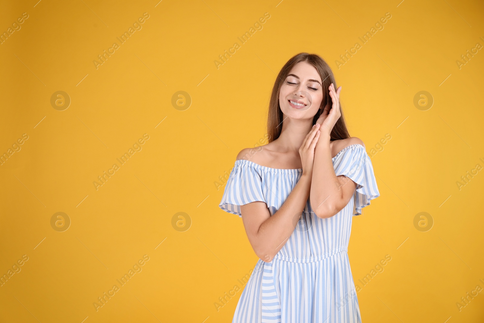Photo of Young woman wearing stylish dress on yellow background. Space for text