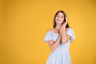 Young woman wearing stylish dress on yellow background. Space for text