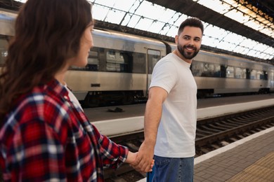 Photo of Long-distance relationship. Couple walking on platform of railway station