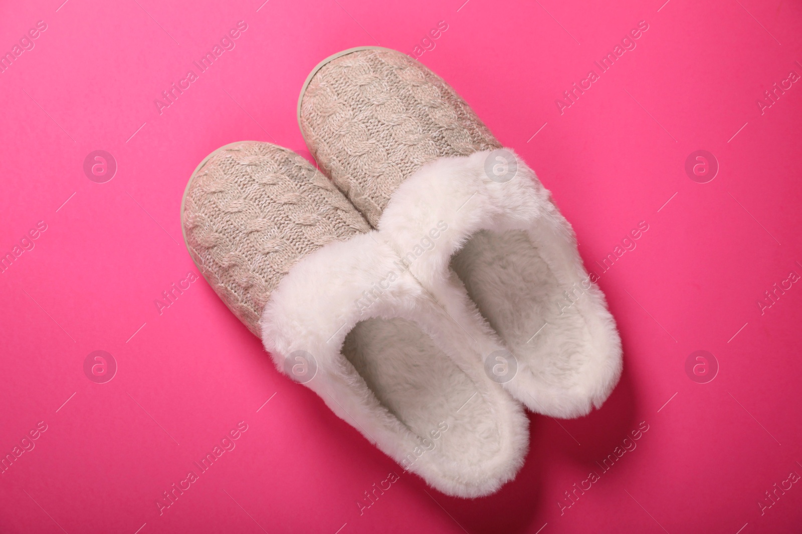 Photo of Pair of beautiful soft slippers on pink background, top view