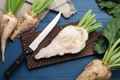 Photo of Whole and cut sugar beets on blue wooden table, flat lay
