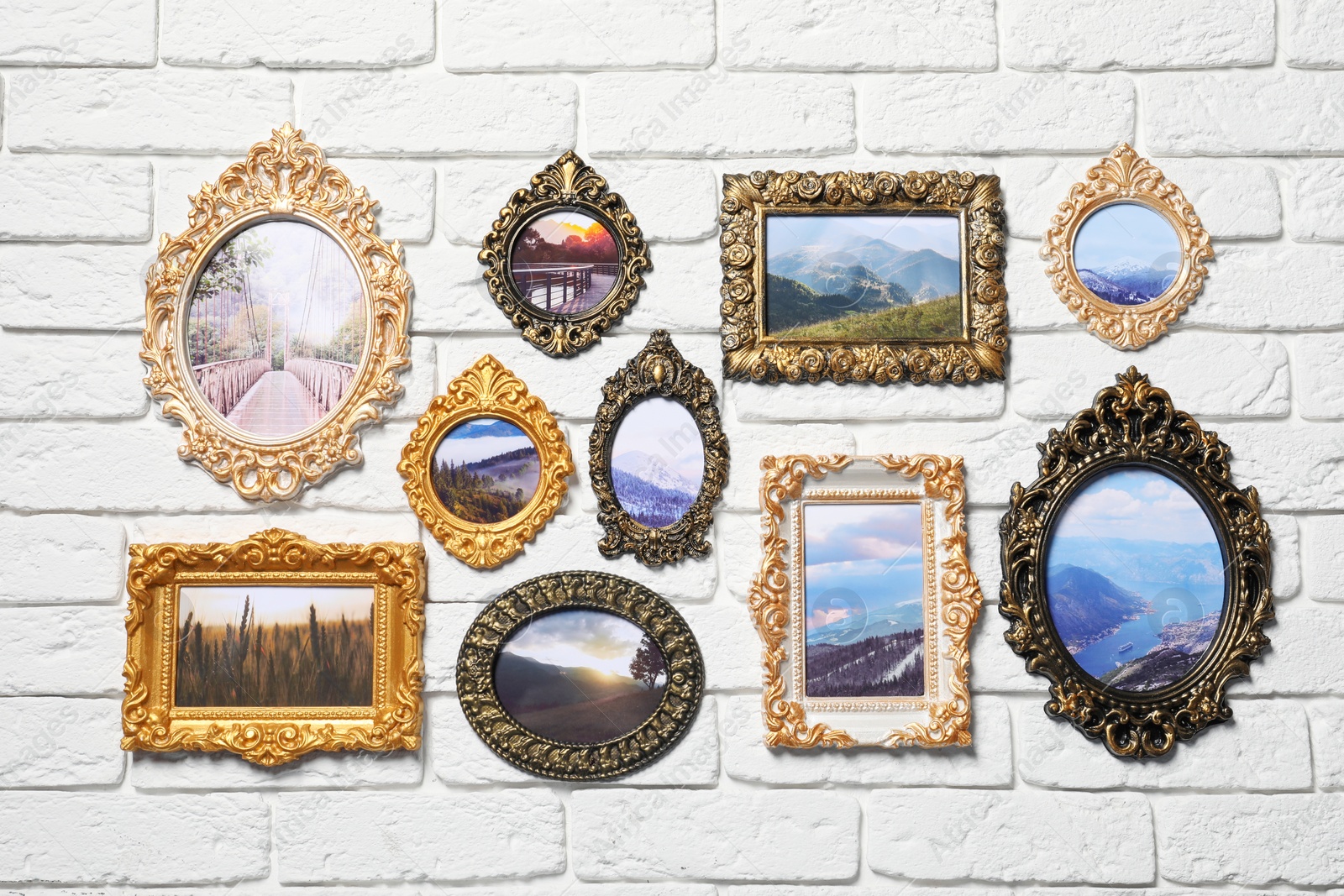 Photo of Vintage frames with photos of beautiful landscapes hanging on white brick wall