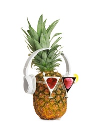 Photo of Funny pineapple with headphones and party glasses on white background