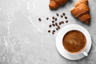 Photo of Tasty fresh croissants and coffee on light grey marble table, flat lay. Space for text