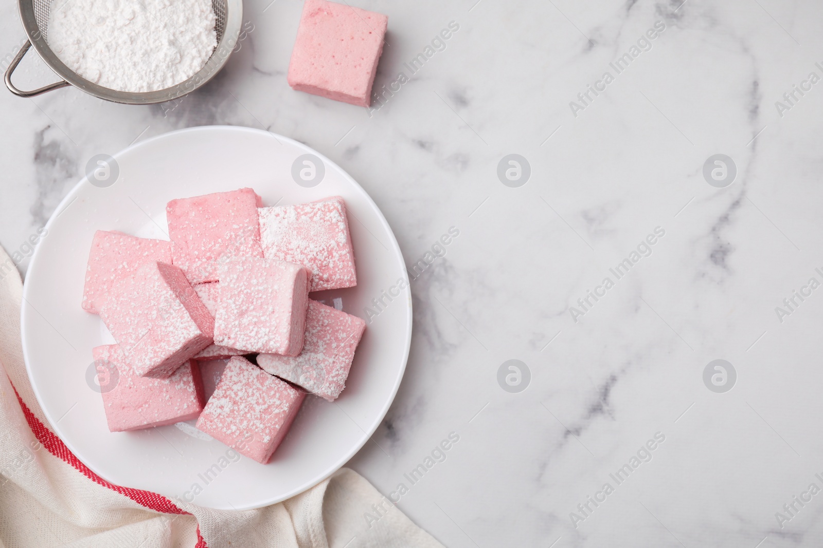 Photo of Plate of delicious sweet marshmallows with powdered sugar on white marble table, flat lay. Space for text