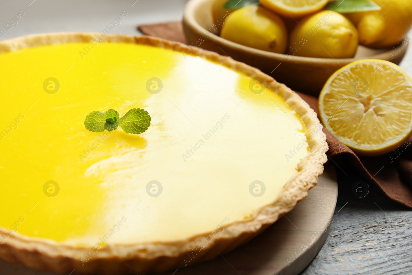 Photo of Delicious homemade lemon pie with mint on wooden table, closeup