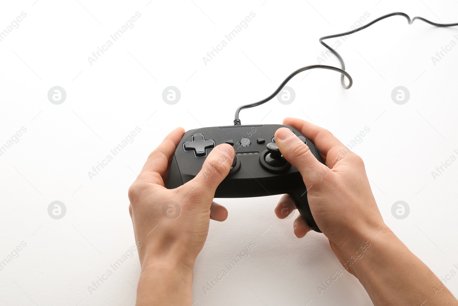 Photo of Young man holding video game controller on white background, closeup