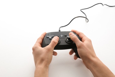 Photo of Young man holding video game controller on white background, closeup