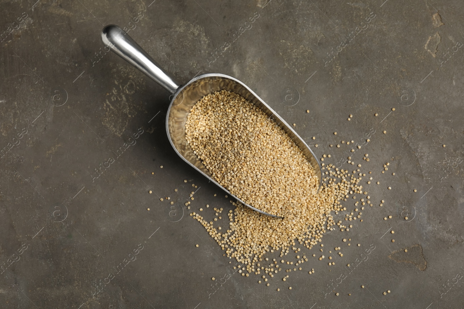 Photo of Metal scoop with white quinoa on grey table, flat lay