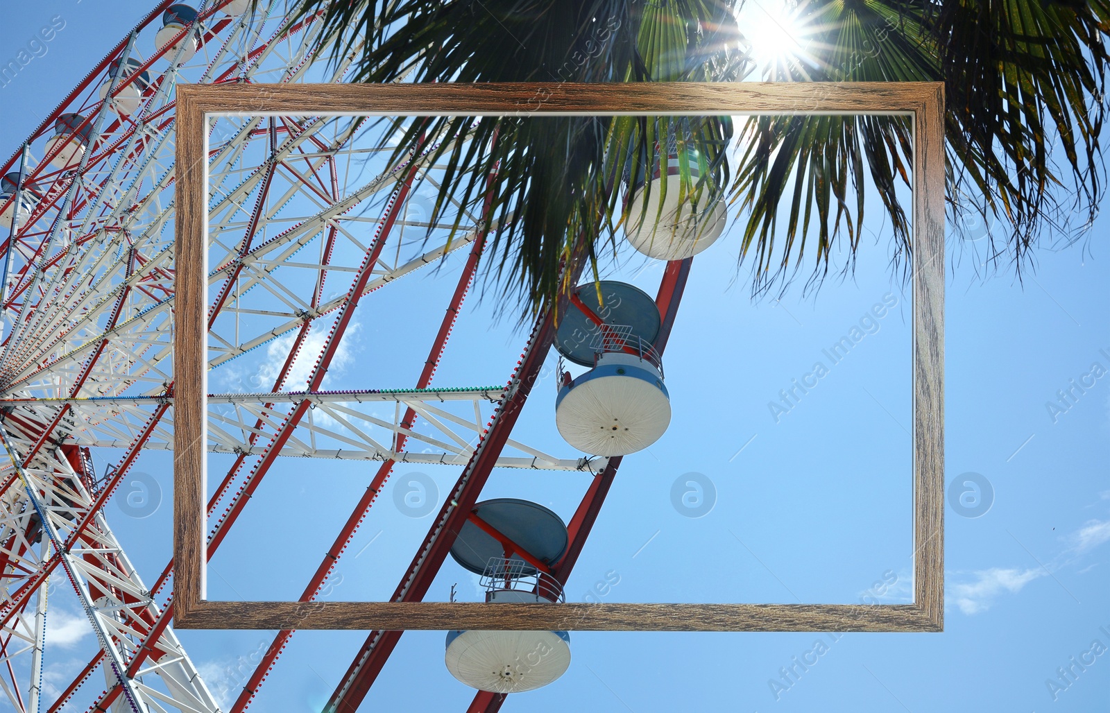 Image of Wooden frame and observation wheel under on sunny day