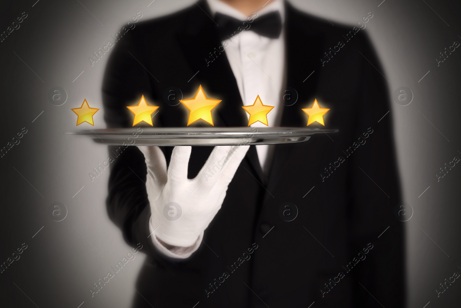 Image of Five Star Luxury Hotel. Waiter with tray on grey background, closeup