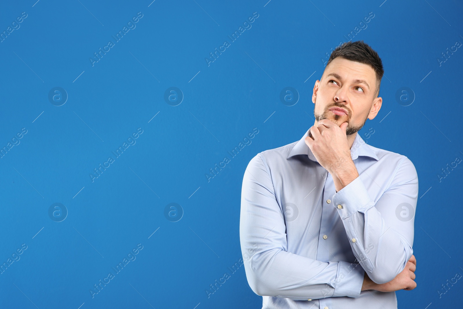 Photo of Thoughtful man on blue background, space for text