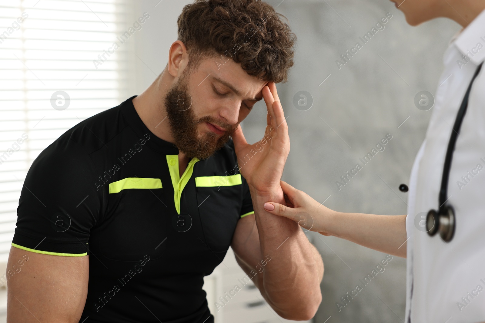 Photo of Doctor examining injured sportsman in hospital, closeup