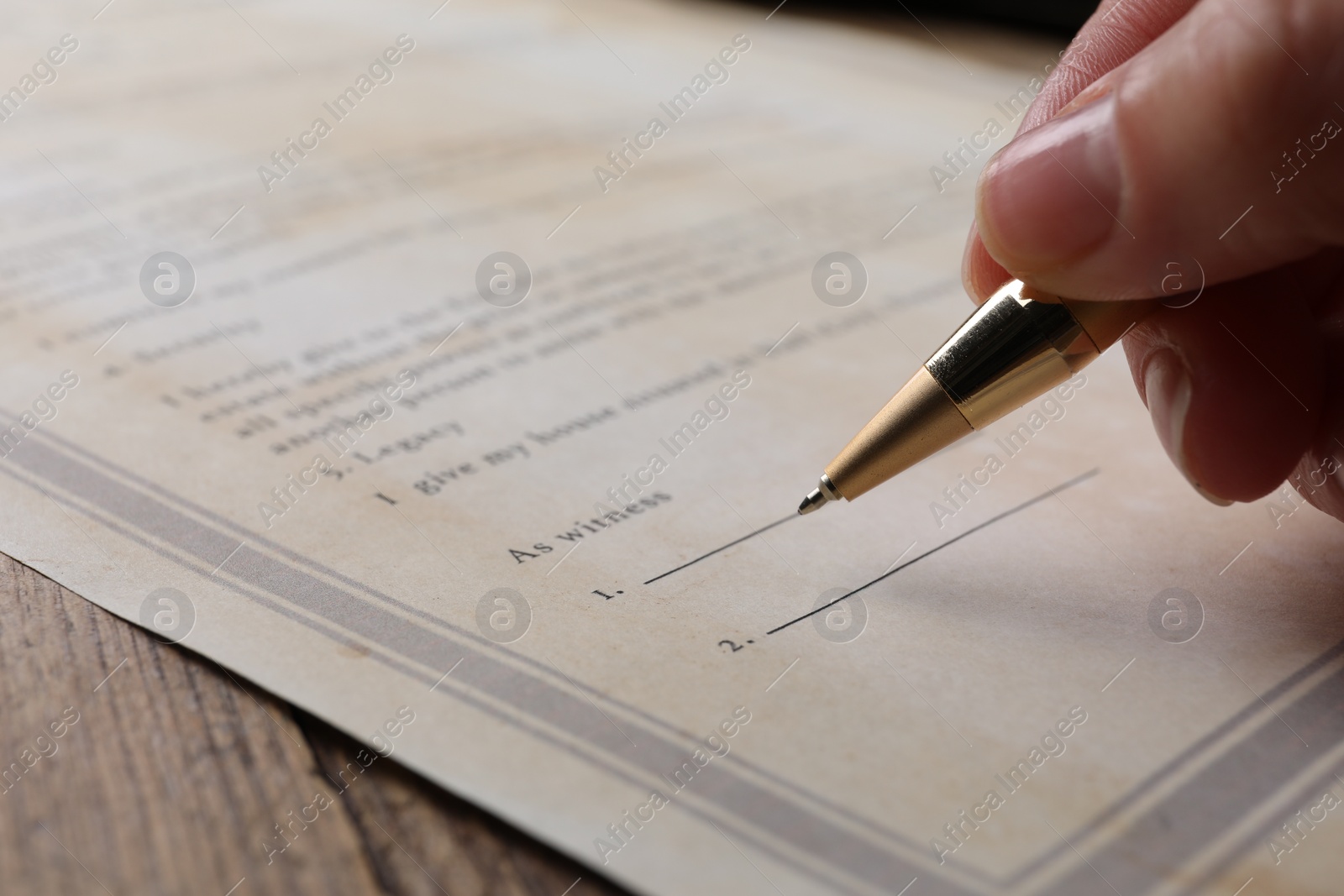 Photo of Woman signing Last Will and Testament at wooden table, closeup