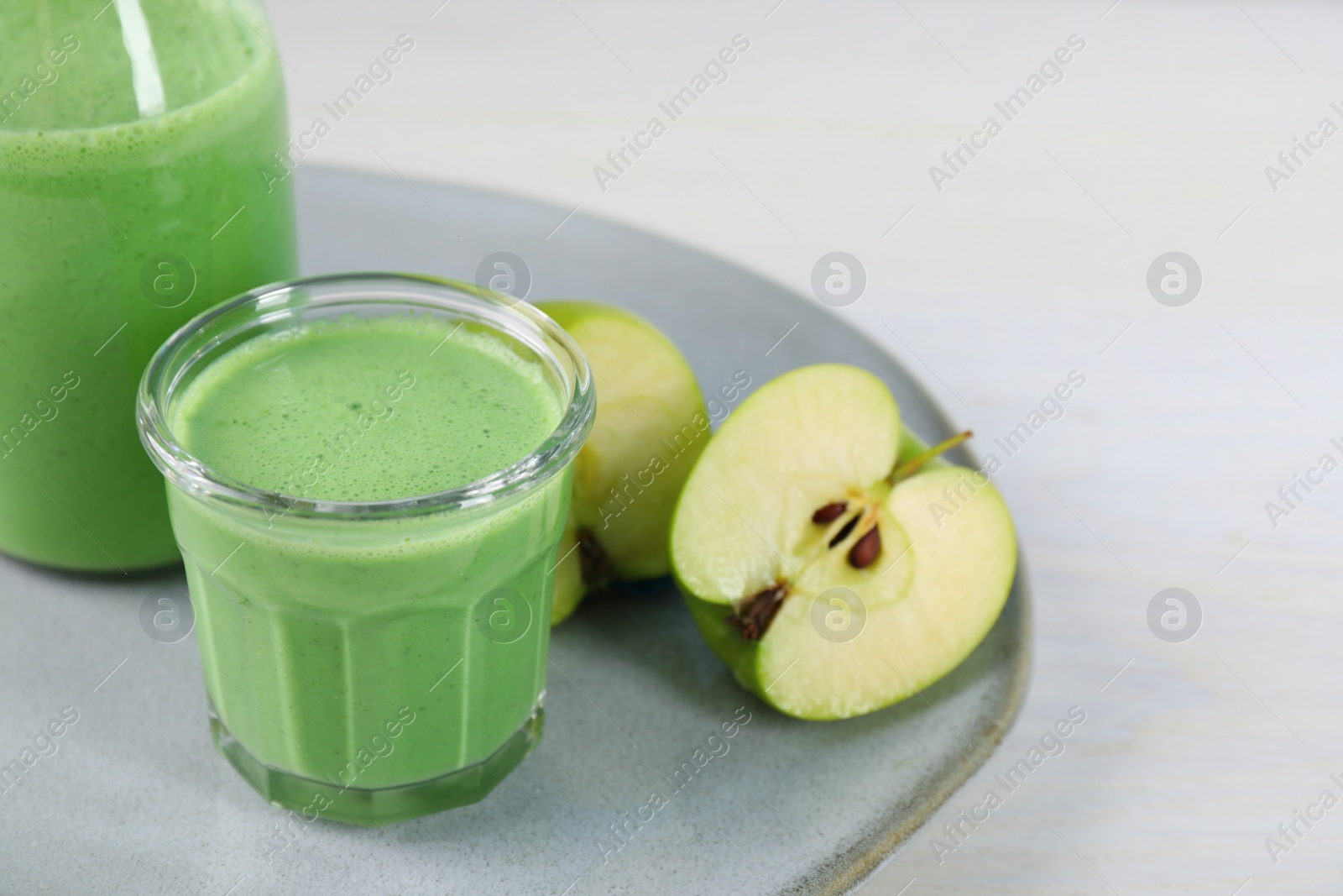 Photo of Tasty fresh apple smoothie on white table, space for text