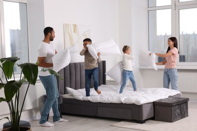 Photo of Happy international family having pillow fight at home
