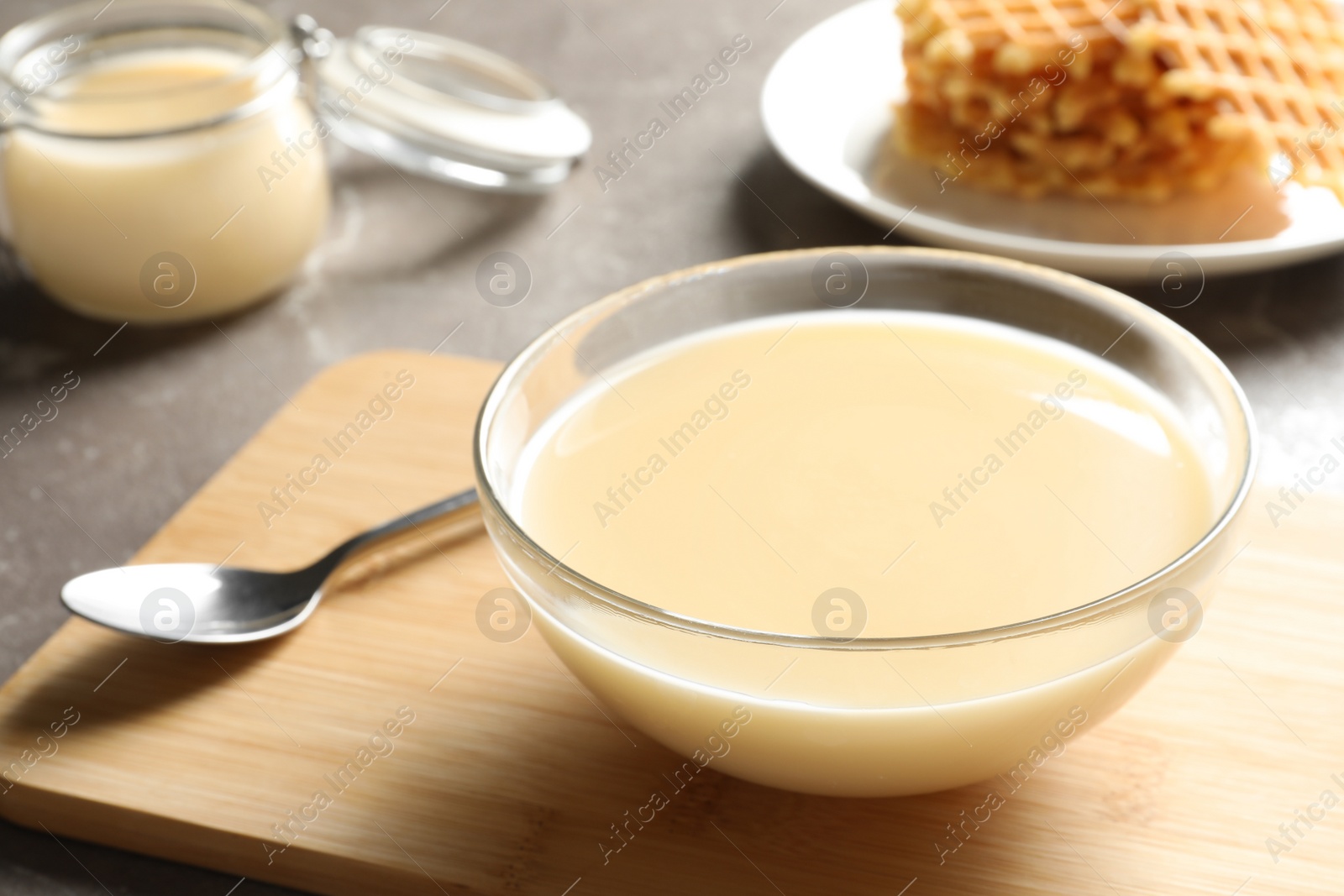 Photo of Bowl of condensed milk served on table, space for text. Dairy products