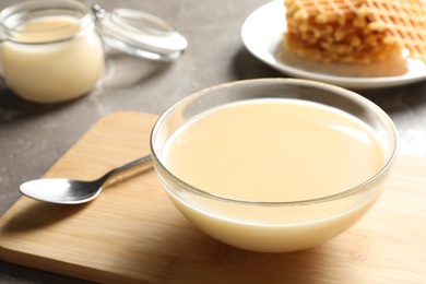 Bowl of condensed milk served on table, space for text. Dairy products